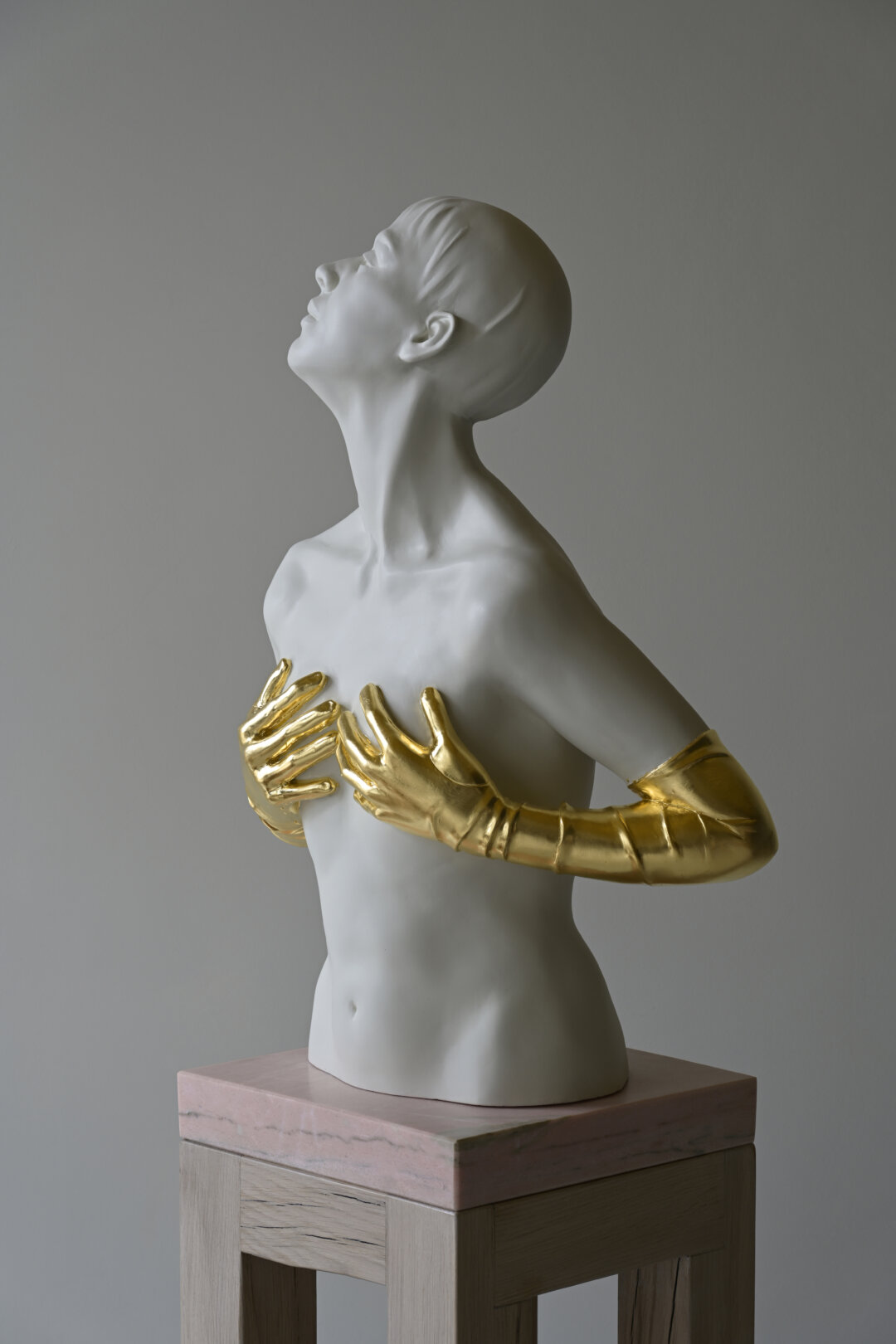 Acryilc sculpture of young woman with gold plated gloves.